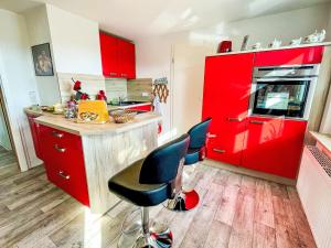 a kitchen with red cabinets and blue chairs at Apartment Ferienwohnung Naturblick Karla Rößler by Interhome in Grüna +12 photos