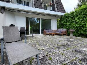 a patio with a chair and a table and a bench at Apartment Terrassenwohnung am See by Interhome in Neuglobsow