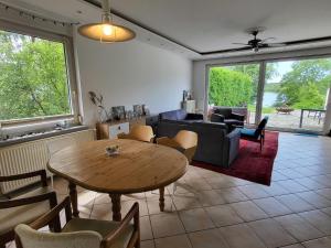 a living room with a table and a couch at Apartment Terrassenwohnung am See by Interhome in Neuglobsow