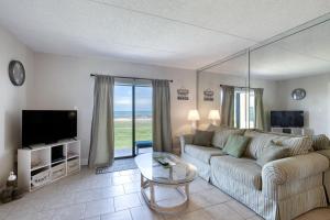 a living room with a couch and a tv at Beach Dont My Vibe in Ormond Beach