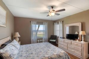 a bedroom with a bed and a ceiling fan at Beach Dont My Vibe in Ormond Beach +34 photos