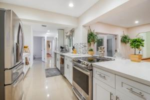 a large kitchen with white cabinets and stainless steel appliances at Casa Aloha Tropical Pool Beach 9 mins Games in Hollywood