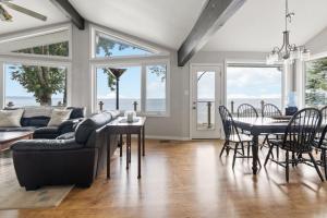 a living room with a couch and a table and chairs at Serene Waterfront Escape On Private Lane in Meaford
