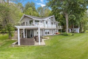 a large white house with a grass yard at Serene Waterfront Escape On Private Lane in Meaford