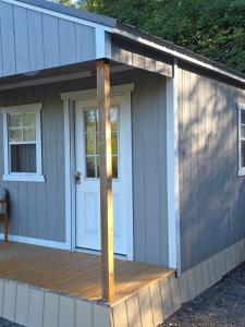 a small shed with a door and a deck at Grey cabin in Kelso