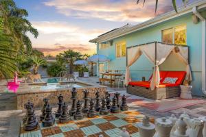 Un patio trasero con un tablero de ajedrez y una casa. en Luxury Villa Pool Jacuzzi Cinema and Game Room, en Fort Lauderdale