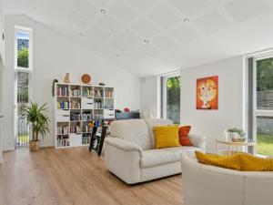 a living room with a white couch and a book shelf at Holiday Home Troels - 945m from the sea by Interhome in Hornbæk