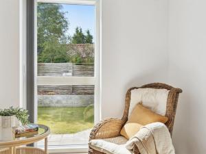 a rattan chair in a room with a window at Holiday Home Troels - 945m from the sea by Interhome in Hornbæk