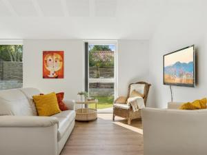 a white living room with a couch and a chair at Holiday Home Troels - 945m from the sea by Interhome in Hornbæk