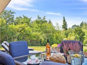 a table with a bottle of wine and two chairs at Holiday Home Troels - 945m from the sea by Interhome in Hornbæk