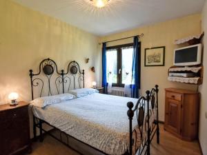 a bedroom with a large bed and a television at Apartment Casa Cavalieri by Interhome in Valdisotto