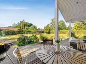 un patio avec un parasol sur une terrasse en bois dans l'établissement Holiday Home Arisa - 300m from the sea by Interhome, à Gedesby