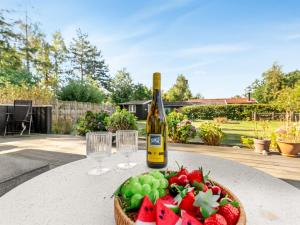 - une bouteille de vin et un bol de fruits sur une table dans l'établissement Holiday Home Arisa - 300m from the sea by Interhome, à Gedesby 14 autres photos