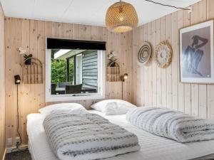 a bedroom with a bed with two pillows on it at Holiday Home Adia - 500m from the sea by Interhome in Hejlsminde +25 photos