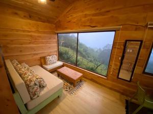 a room with a large window in a log cabin at Cabañas Emerald Forest in Concepción