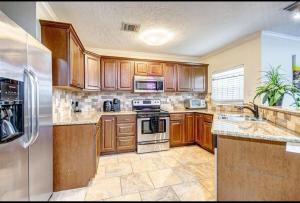 una cucina con armadietti in legno ed elettrodomestici in acciaio inossidabile di 3BR Home, 2mi Astros, 2mi Dynamo, King Bed, Med Center a Houston