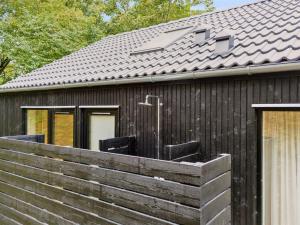 una casa con una valla de madera delante de ella en Holiday Home Aggi - 850m from the sea by Interhome, en Kårup