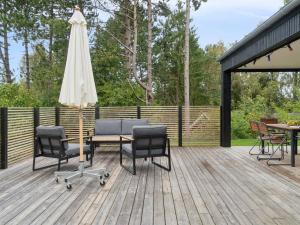 un patio con una mesa y una sombrilla en una terraza en Holiday Home Aggi - 850m from the sea by Interhome, en Kårup