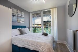 ein Schlafzimmer mit einem Bett und einem großen Fenster in der Unterkunft Vista Verde - Luxury City Penthouse 2BR - Sleeps up to 6 - Parking in Birmingham