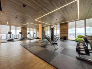 Un gimnasio con cintas de correr y equipos de ejercicio en un edificio. en Asoke Luxury High Rise - Steps to BTS and MRT - WiFi, en Makkasan
