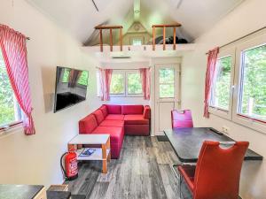 a living room with a red couch and a table at Holiday Home -2 by Interhome in Stuer