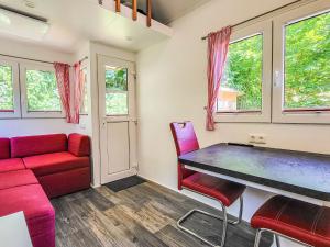 a living room with a red couch and a table at Holiday Home -2 by Interhome in Stuer +16 photos