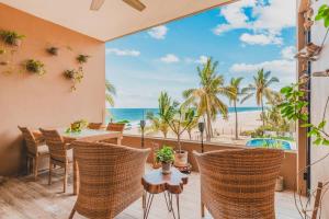 a patio with a table and chairs and a view of the beach at Casa De Vigil Beachfront Oasis Ocean Views Pool in San Francisco