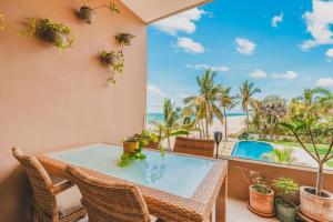 a balcony with a table and chairs and a view of the ocean at Casa De Vigil Beachfront Oasis Ocean Views Pool in San Francisco