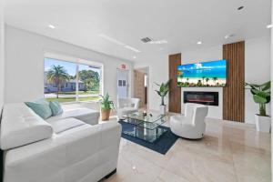 Una sala de estar con un sofá blanco y una chimenea. en Baby Camellia Modern, luxurious and spacious house, en Fleetwood Manor
