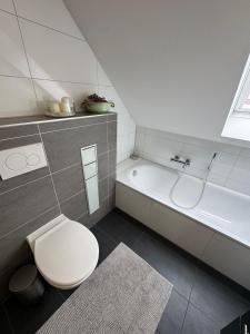 a bathroom with a toilet and a bath tub at Haus Auszeit in Cremlingen