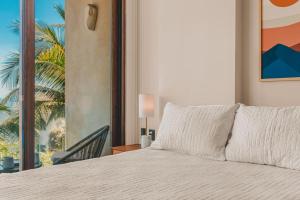 a bedroom with a bed with a view of a palm tree at Limited Time Offer Luxe 2 BR with Plunge Pool in Sayulita +40 photos