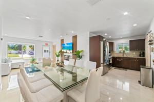 Un comedor y una cocina con una mesa de cristal y sillas. en Baby Camellia Modern, luxurious and spacious house, en Fleetwood Manor