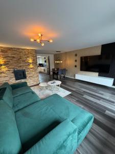 a living room with a large green couch and a dining room at Haus Auszeit in Cremlingen
