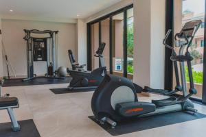 a gym with treadmills and ellipticals in a room at Casa Armada Beachfront Condo with Pool in San Francisco