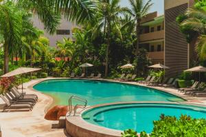 a pool at a resort with chairs and umbrellas at Casa Armada Beachfront Condo with Pool in San Francisco