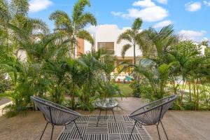 a patio with two chairs and a table and palm trees at Tranquil Jungle Retreat w Pool Bikes and Walk to Town in San Francisco