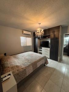 a bedroom with a bed and a chandelier at Estancias Nava #2 in San Antonio