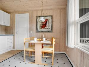 a dining room with a table and chairs and a painting at Holiday Home Aleth - 800m from the sea by Interhome in Gedesby