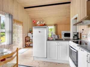 a kitchen with white appliances and a wooden ceiling at Holiday Home Aleth - 800m from the sea by Interhome in Gedesby +9 photos
