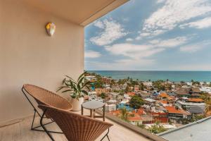 a balcony with chairs and a view of the ocean at Elite 2BR 2BA Ocean Views Rooftop Pool in Sayulita