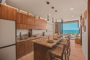 a large kitchen with a long table with chairs at Elite 2BR 2BA Ocean Views Rooftop Pool in Sayulita