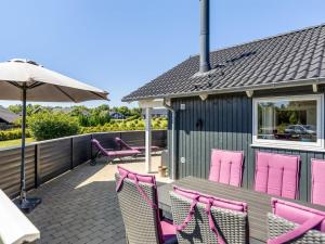 a deck with pink chairs and an umbrella at Holiday Home Rosamunde - 700m from the sea by Interhome in Skovbyballe +16 photos