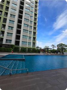 un grand immeuble d'appartements avec une grande piscine dans l'établissement City Center, Cozy room with Pool, Washing Machine, à Udon Thani