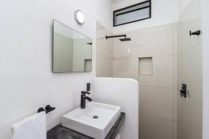 a white bathroom with a sink and a mirror at 4 by 4 means 8 is great in San Pancho in San Francisco +54 photos