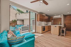 a living room with a blue couch and a kitchen at Breezy elegance Sayulita style in Sayulita