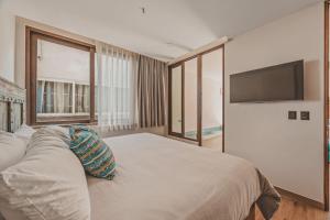 a bedroom with a large bed and a flat screen tv at Breezy elegance Sayulita style in Sayulita +48 photos