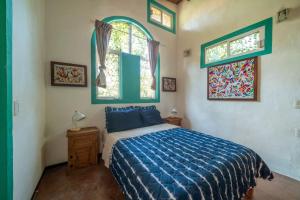 1 Schlafzimmer mit einem Bett mit blauer Decke und 2 Fenstern in der Unterkunft Casa Happy Sol Boa Pool and Beach Vibes in San Francisco