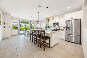 a kitchen with white cabinets and a large island with bar stools at The Fiddyment Roost in Roseville