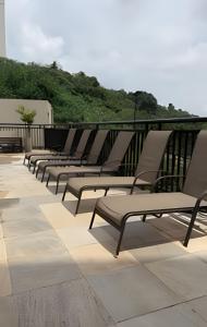 a row of lounge chairs sitting on a balcony at Apartamento inteiro com vaga, varanda e piscina in Cotia