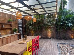 patio z drewnianym stołem i czerwonymi krzesłami w obiekcie Không gian xanh an yên bên Hồ Tây w mieście Hanoi